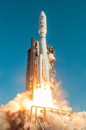 A rocket surrounded by a plume of smoke as it launches