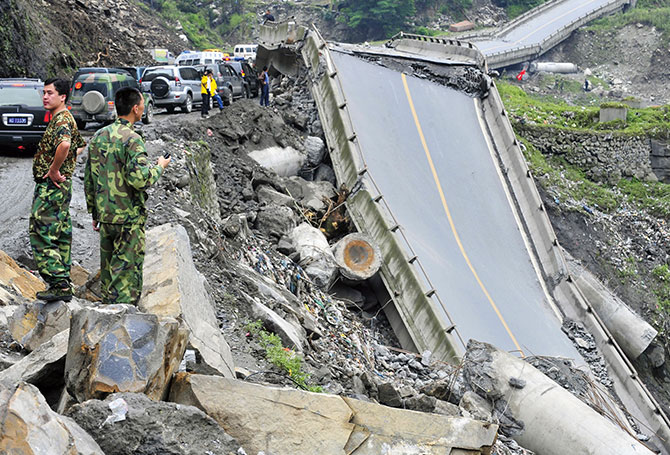 Cars lined up next to a collapsed highway