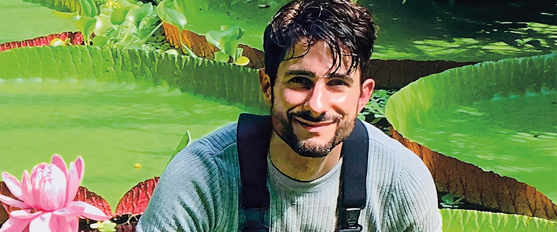 Photo of a person smiling against backdrop of lily pads