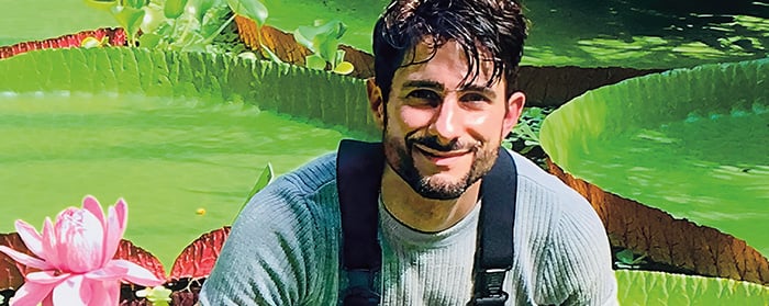 Photo of a person smiling against backdrop of lily pads