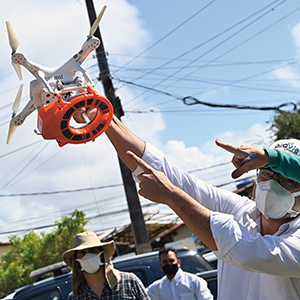 Photo of people pointing to a mosquito drone