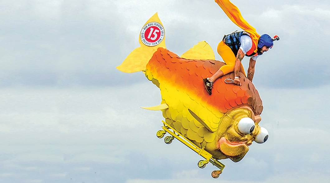 Image of a person riding a fish cart on wheels
