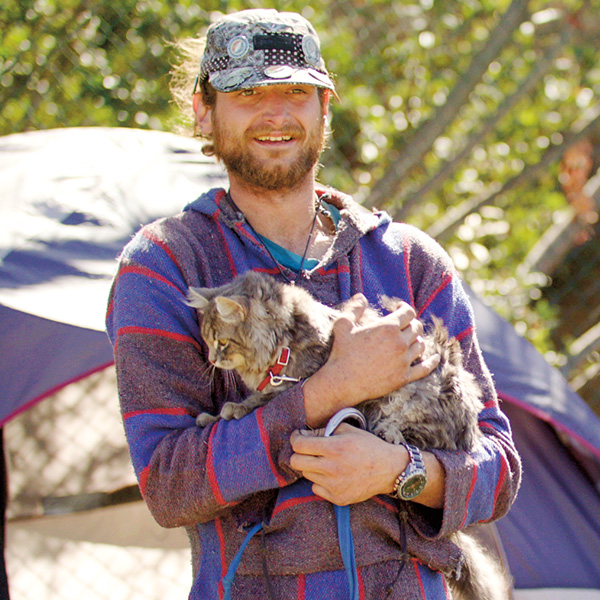 Photo of a homeless person holding their pet cat