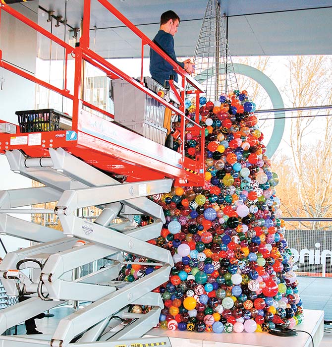 Enlargeable photo of person next to a large pile of glass ornaments
